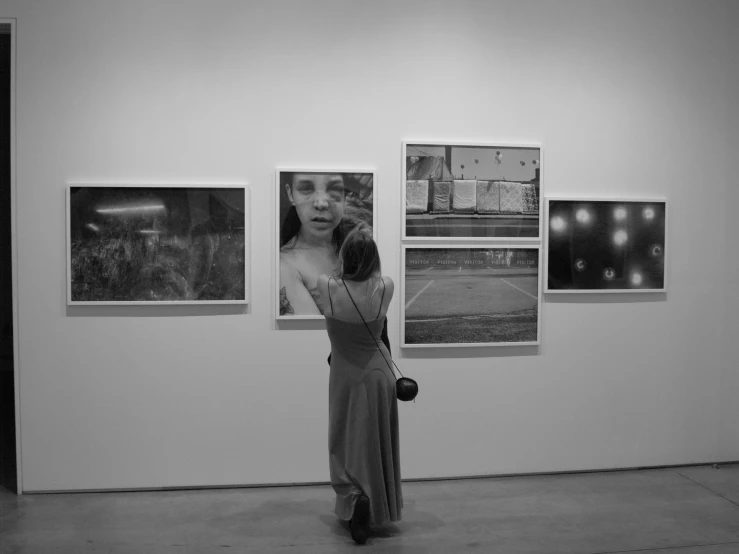 black and white po of woman looking at paintings