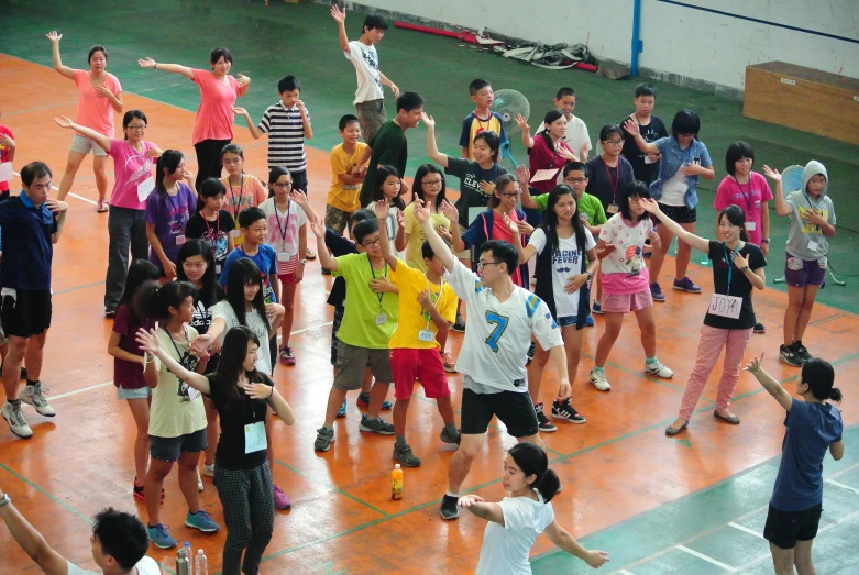 children in school uniforms are standing on a court with one girl on the other side