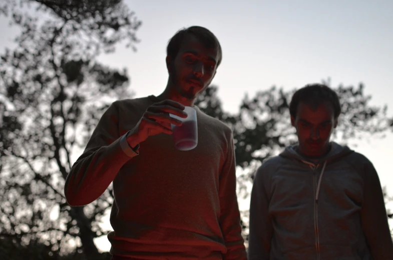 two men with red painted faces looking at a camera