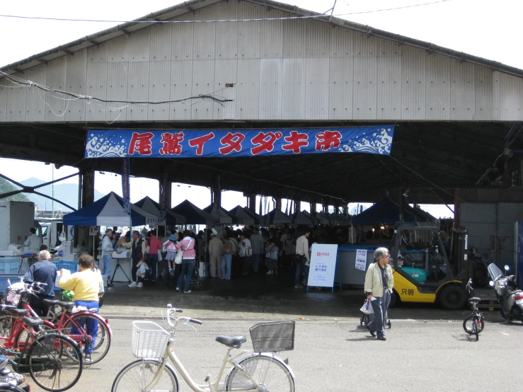 a crowd of people standing in front of a market