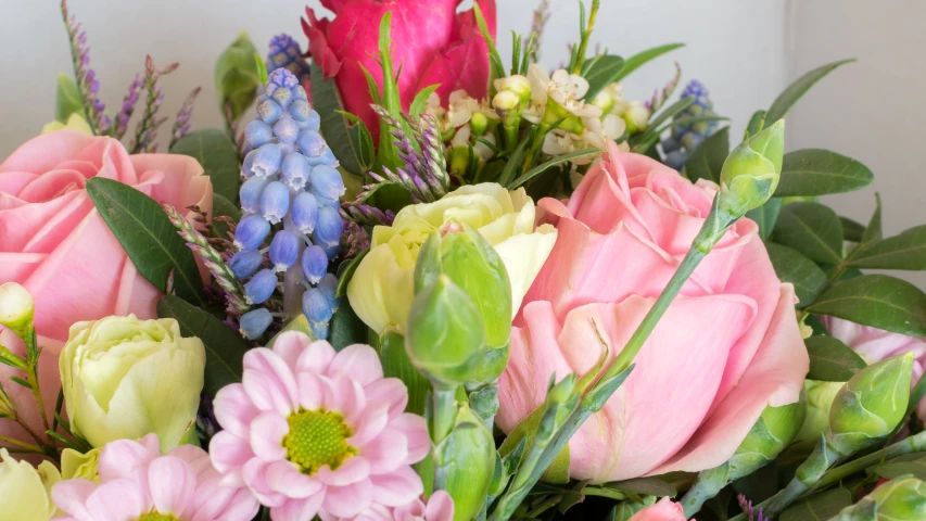 a closeup of a vase containing pink, green and yellow flowers