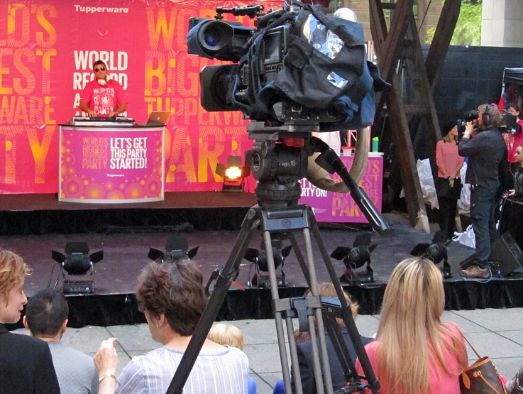 a cameraman on the stage in front of people