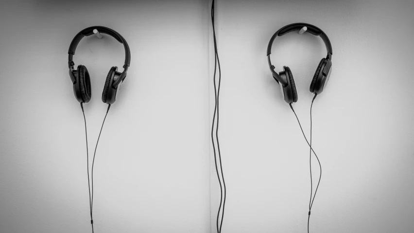 a pair of headphones are hanging up against the wall