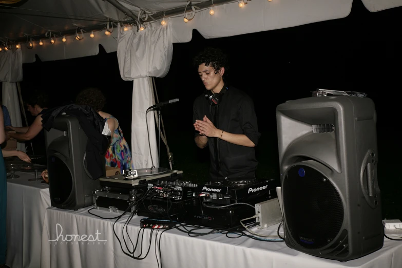 man mixing records at a table at an outdoor music event