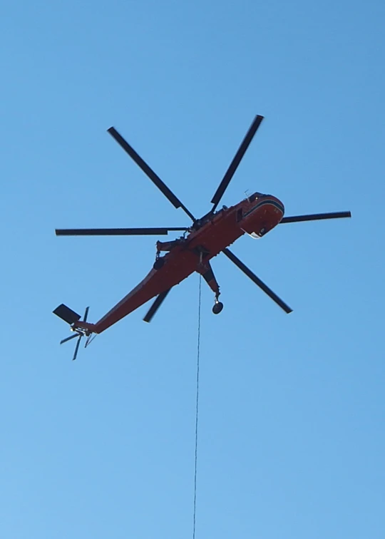 a helicopter is being lowered by a helicopter wire