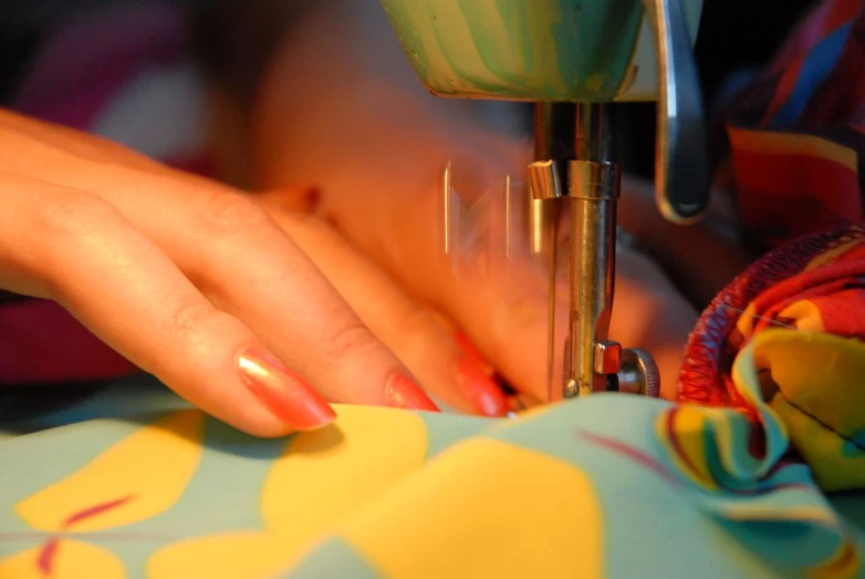 the woman is using the sewing machine to sew the dress