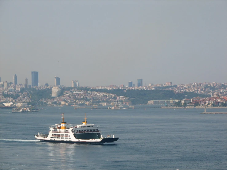 the ferry boat is in the ocean with a view of a city