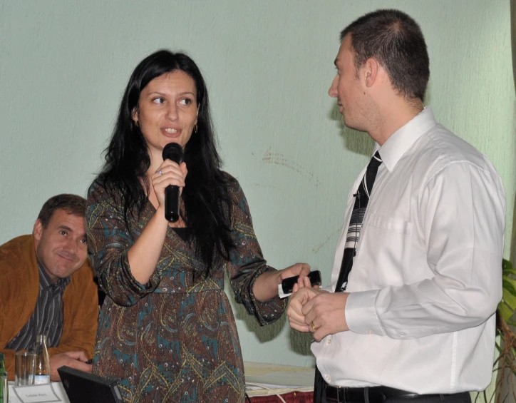 there are two people standing at a podium and one person speaking