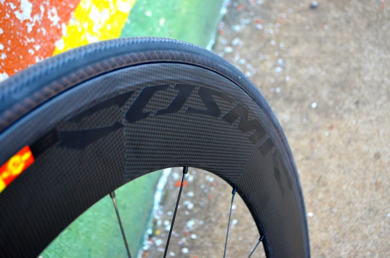 a black bicycle wheel with yellow, red and orange words