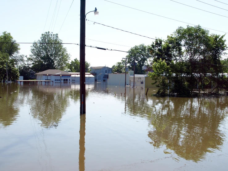 a flooded street, buildings, and street lamp