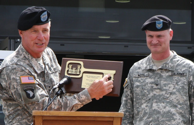 two military men are presenting the medal to each other