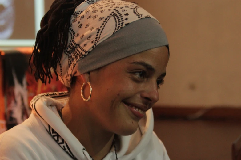 a woman wearing a bandana, smiling for the camera