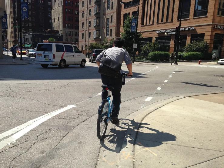 man riding a bike down the middle of the road in a city