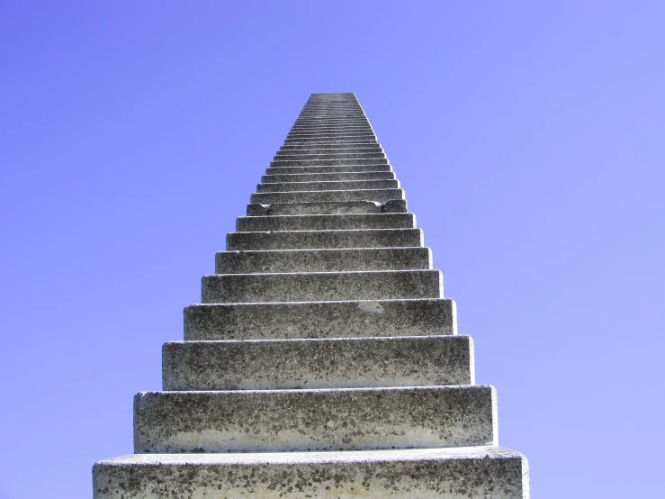 a long stone staircase set against a deep blue sky