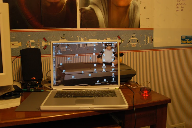 a laptop computer on top of a desk with a large screen