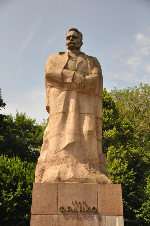 a big statue sitting next to a forest filled with lots of trees