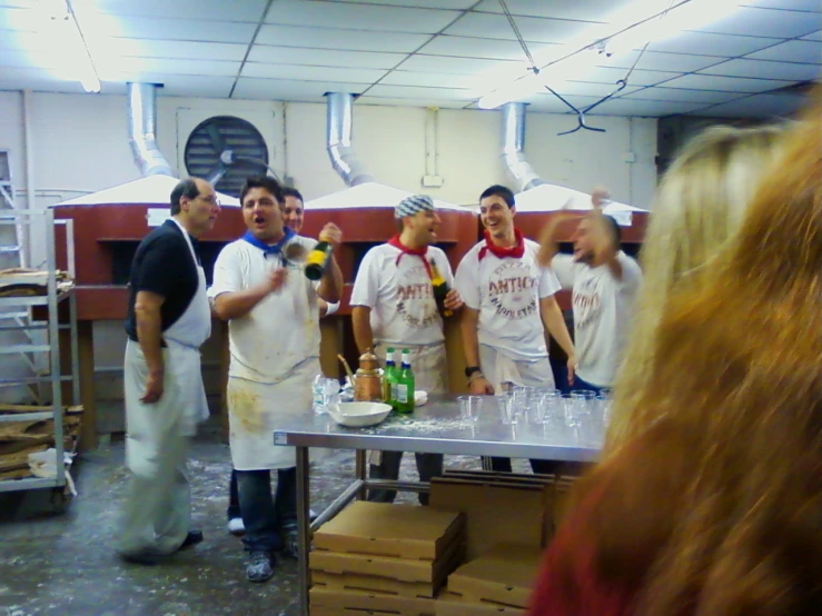 people wearing white aprons standing around a counter