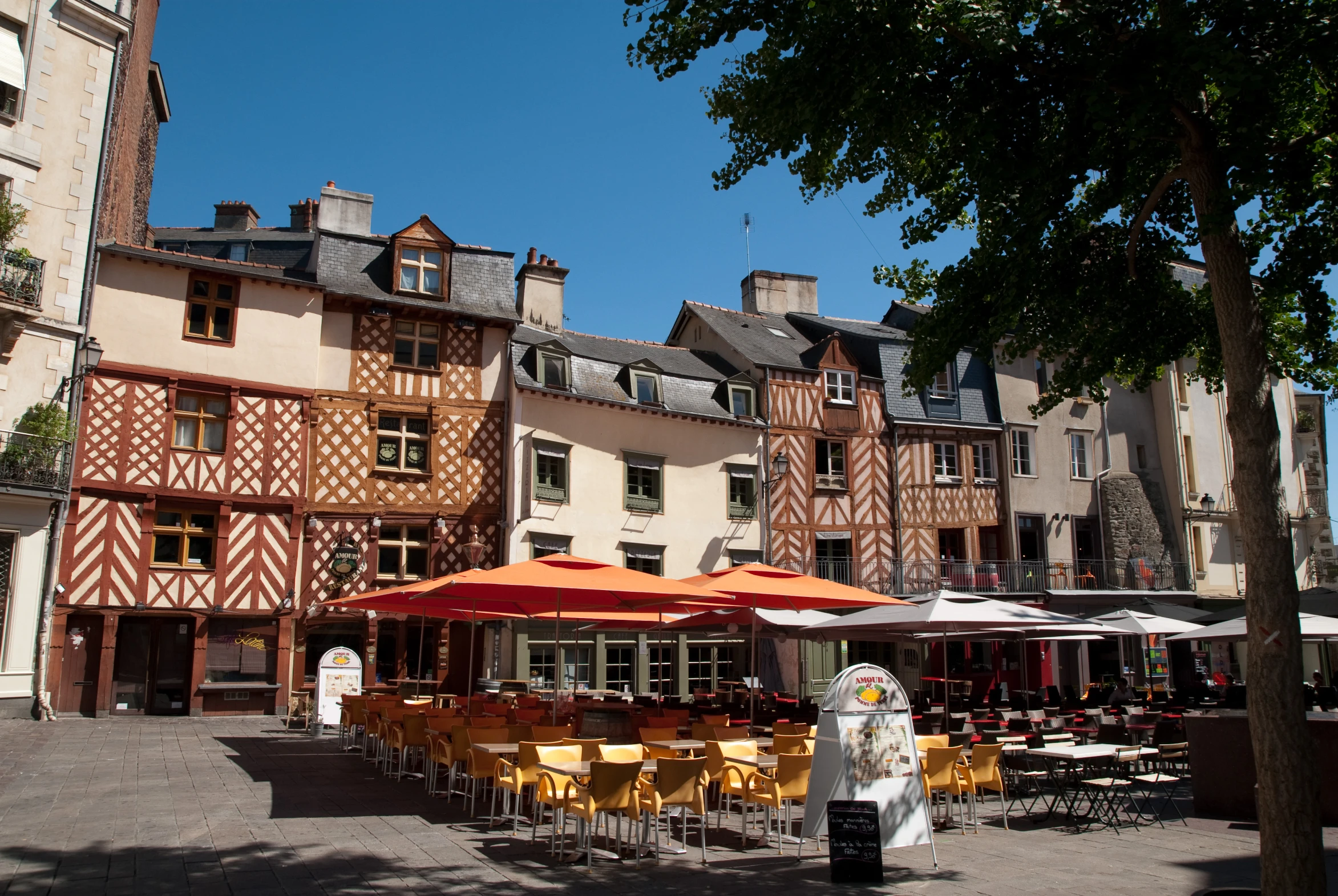 a city street lined with a variety of buildings and chairs