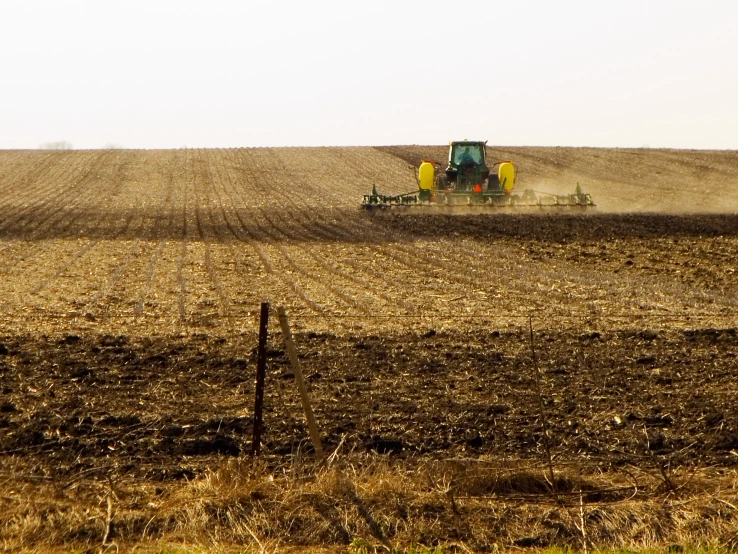 tractor plowing a field of plowed land