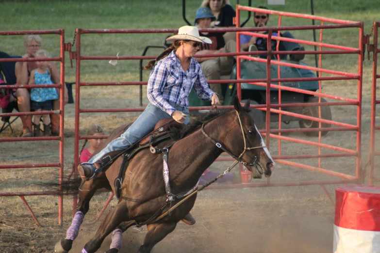 a woman on top of a horse in a rodeo