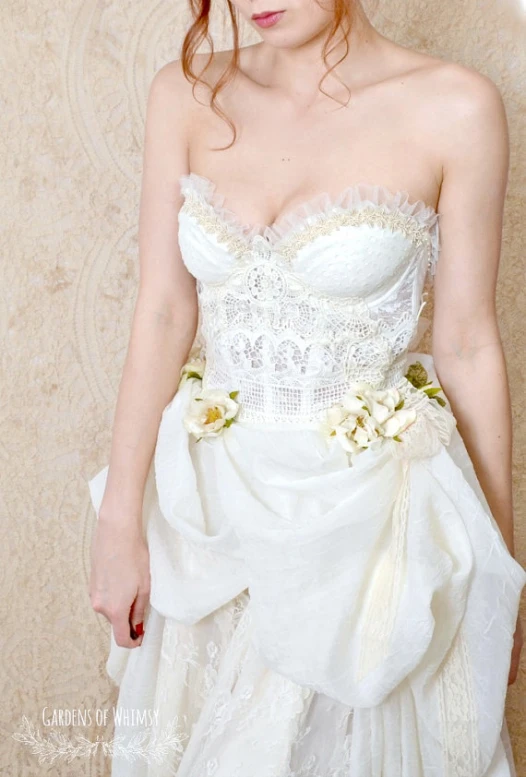 a woman in a wedding dress with flowers on her waist