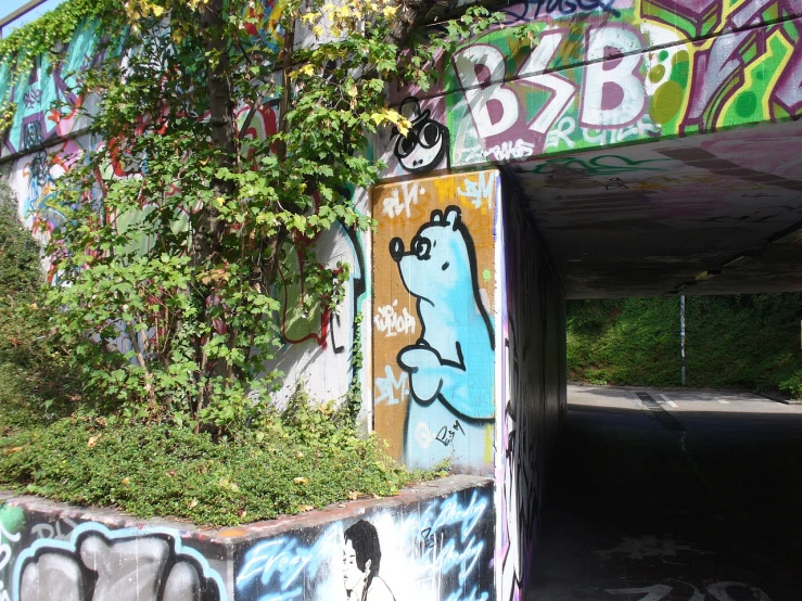 an overpass with graffiti on it and a bear sitting in the center