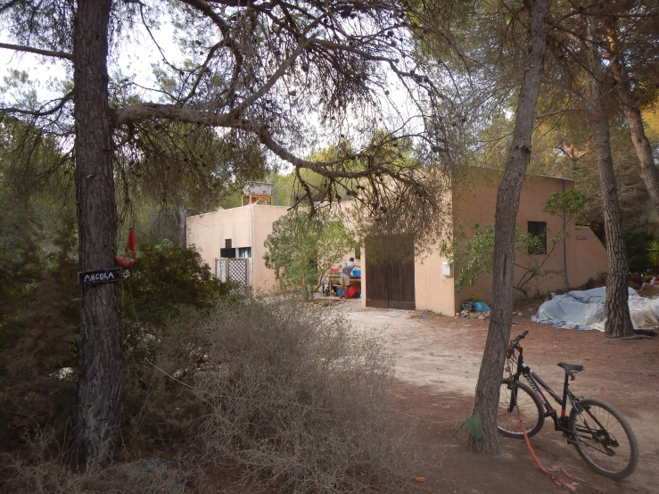 a bicycle parked in front of a house in a wooded area