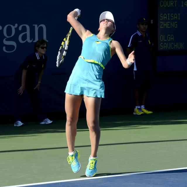 a young woman serving in a tennis match