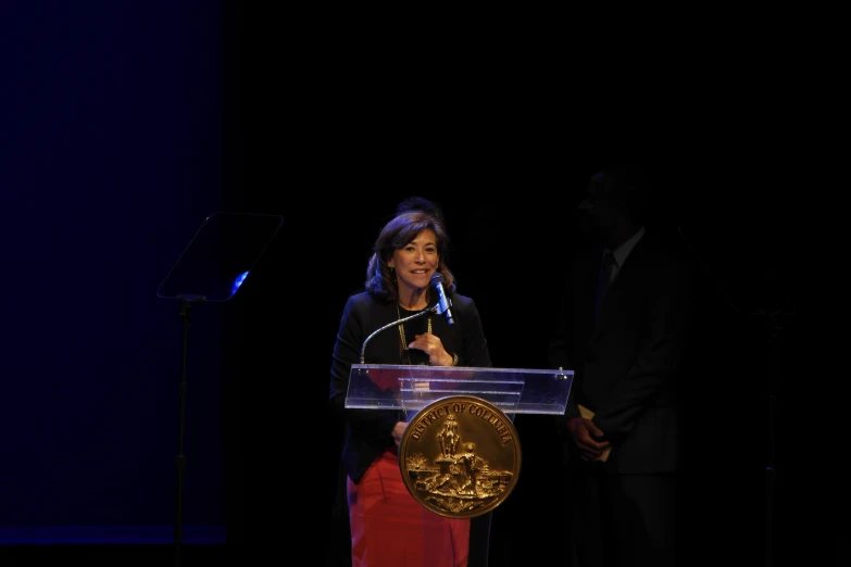 a woman giving a speech at a podium
