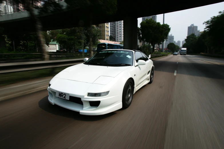 there is a white sports car driving down the road