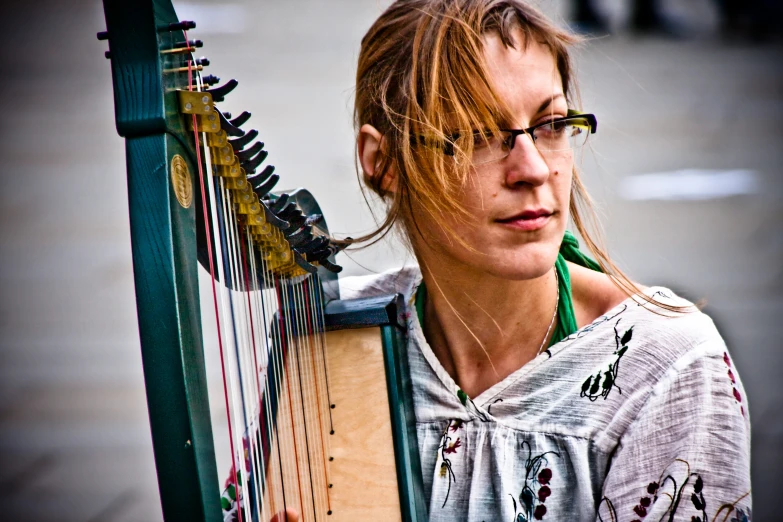 a woman with glasses is playing an harp
