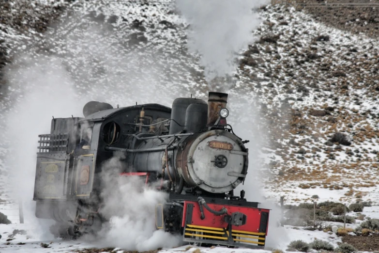 steam rising out of the back of a train traveling through snow