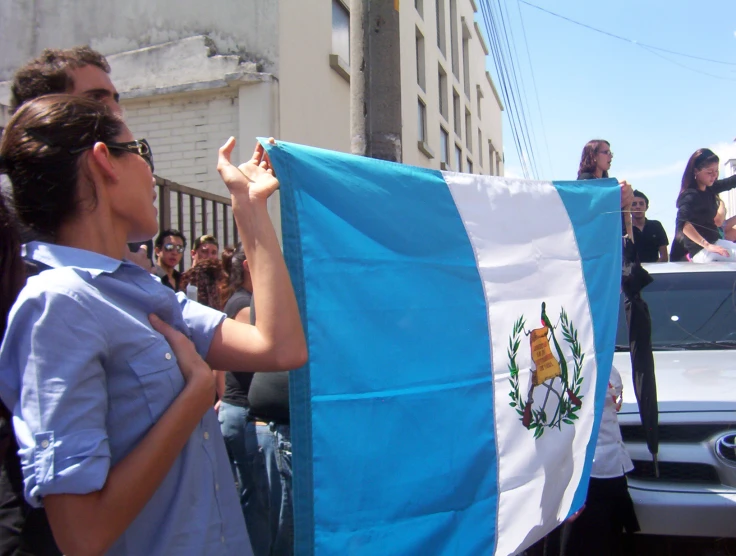 a crowd of people standing around and looking at a large argentina flag