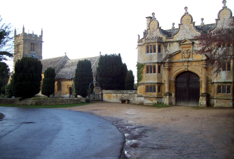 an old building with a tree and stone pathway