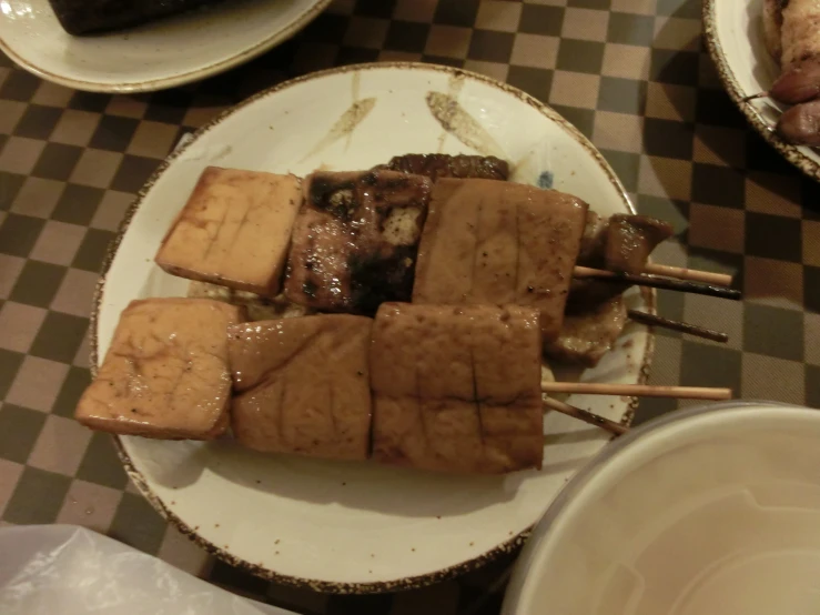 tofu is sitting on a plate with toothpicks stuck in it