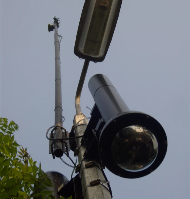 there are two cameras attached to the side of a telephone pole