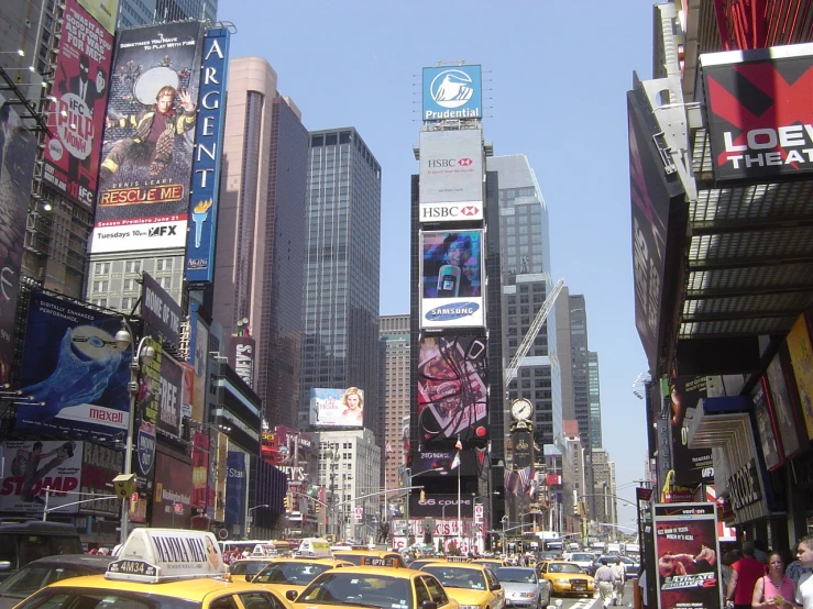 yellow taxi cabs and cars in a city with tall buildings