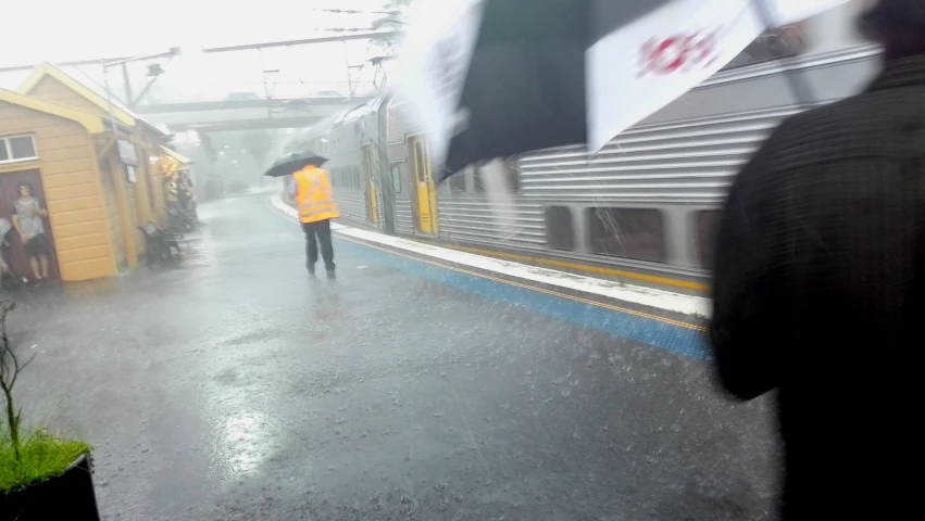 a person holding an umbrella standing on a platform