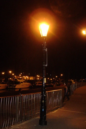 a lamp post is lit up by the street lights
