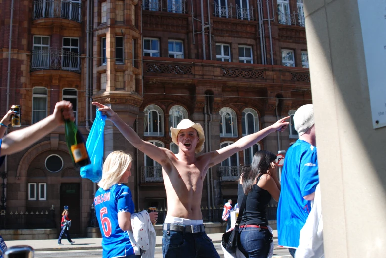 a man with his arms spread wide outside of an old building