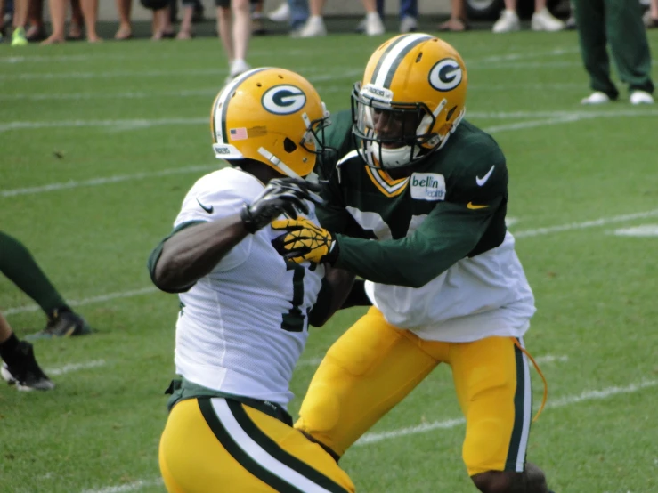 two men in uniforms playing football on grass