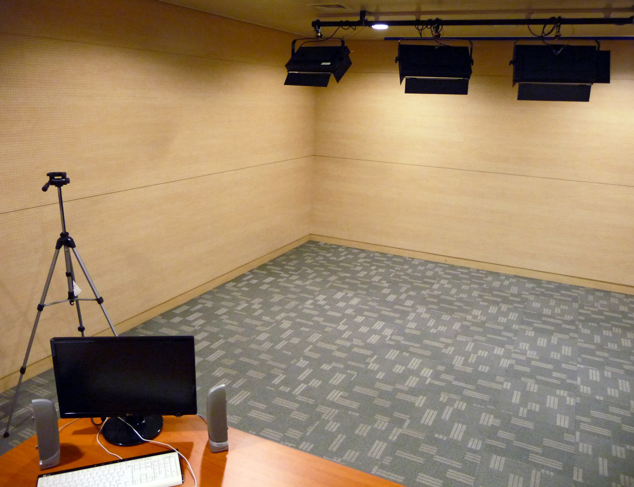 an empty room with an on camera light and a screen