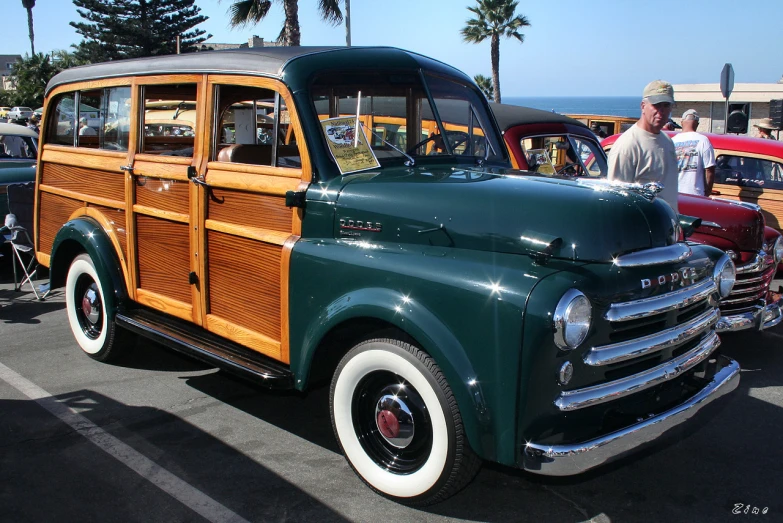 people are gathered around an antique bus at a car show