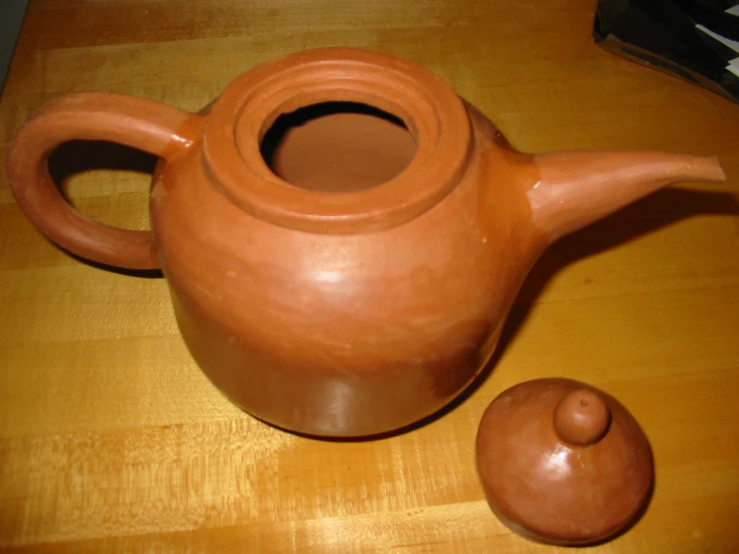 a brown pottery tea pot and small container