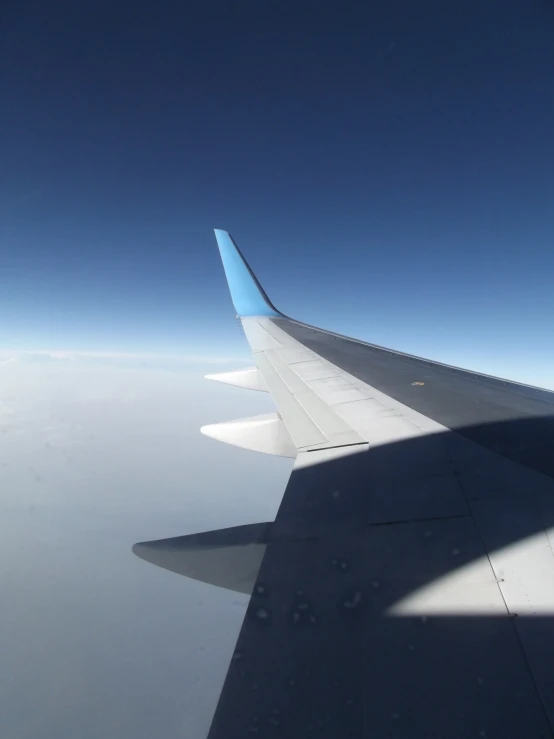 the wing of an airplane with blue tinted markings