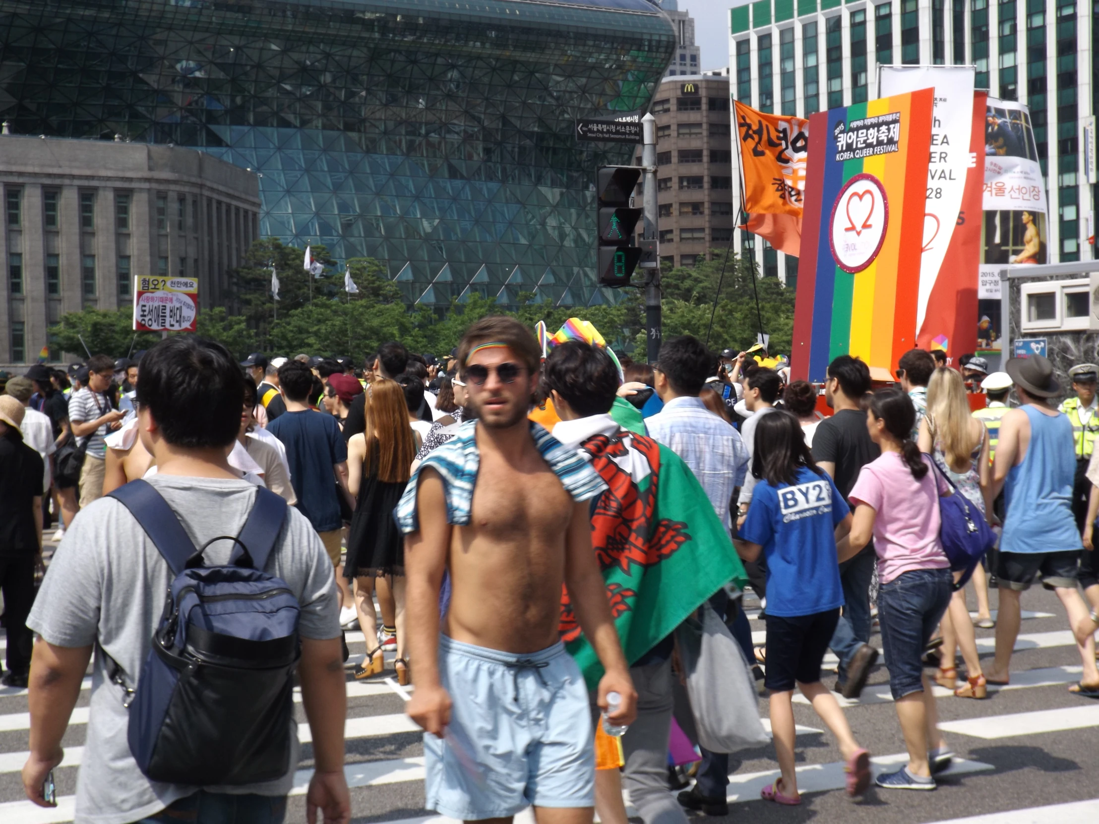 a crowd of people are crossing the street in front of a building