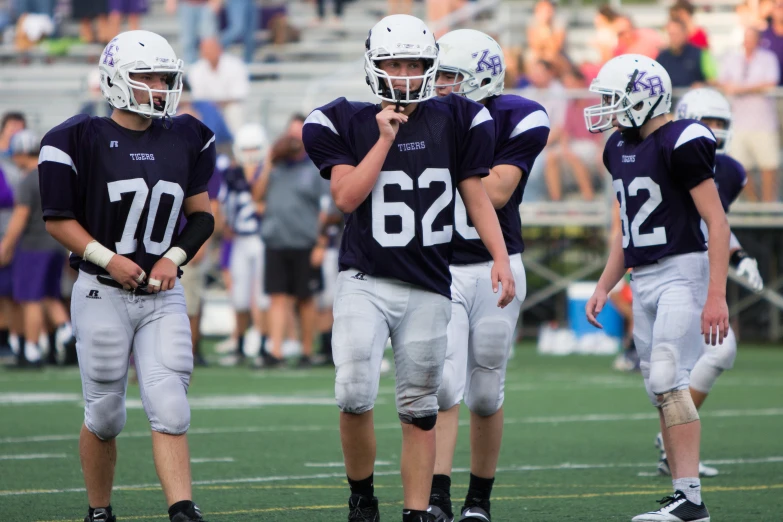 a group of young football players stand together on a field