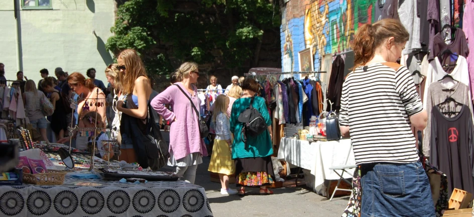 a number of people looking at items outside