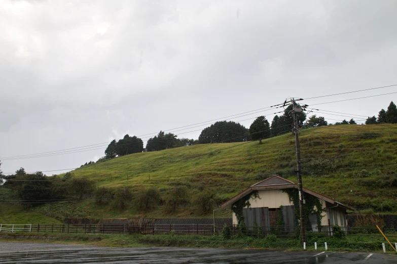 a house with a small roof and a steep hill behind it