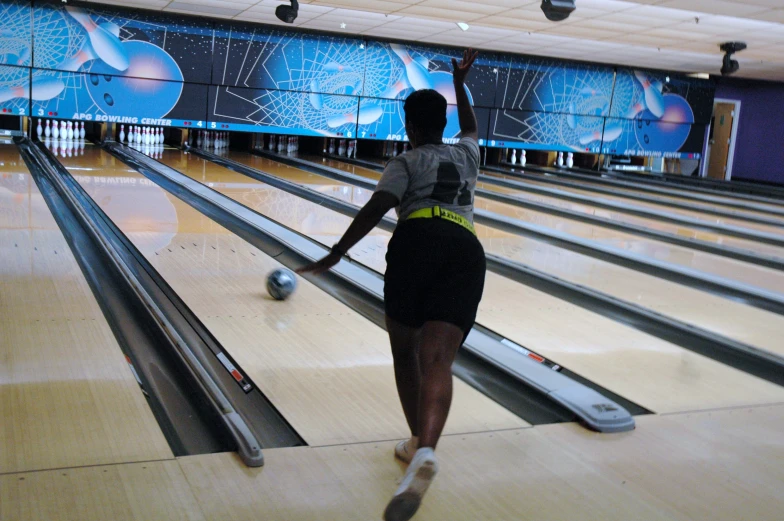 a woman holding her leg up in bowling alley